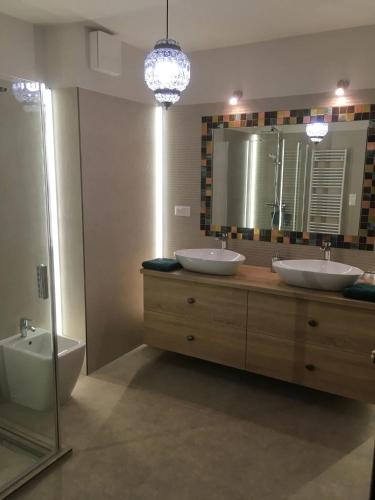 a bathroom with two sinks and a tub and a mirror at Thermal Forest Apartment in Kiskunhalas