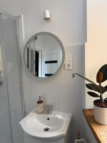 a white bathroom with a sink and a mirror at Pod Aniołami in Wałbrzych