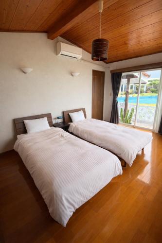 two beds sitting next to each other in a bedroom at 478 retreat in Yoron