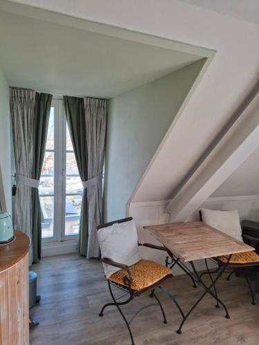 a room with a table and two chairs and windows at El Puerto Bed and Breakfast in Hoorn