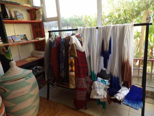 a rack of clothes hanging in a room with a window at Auberge Triskell in Nouakchott