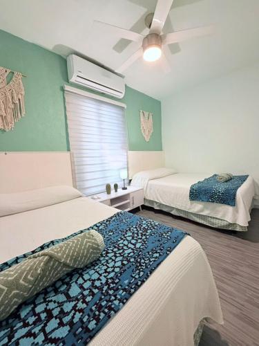a bedroom with two beds and a ceiling fan at MARLIN TURQUESA DEPARTAMENTOs FRENTE AL MAR in Cancún