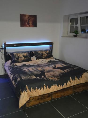a bed in a bedroom with a wooden frame at Le Marronnier in Bastogne