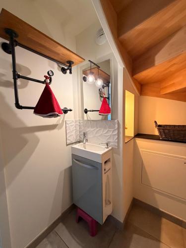 a bathroom with a sink and two red lights at Maison La Bullette à 10 min de Pontarlier in Bulle