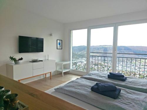 a white room with a bed and a large window at Moselsteig Lodge in Starkenburg