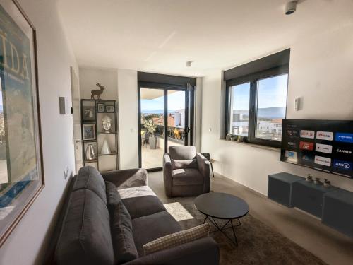 a living room with a couch and a chair and windows at Seaview Residence Krk 2 Bedrooms 2 Bathrooms Free Parking in Krk