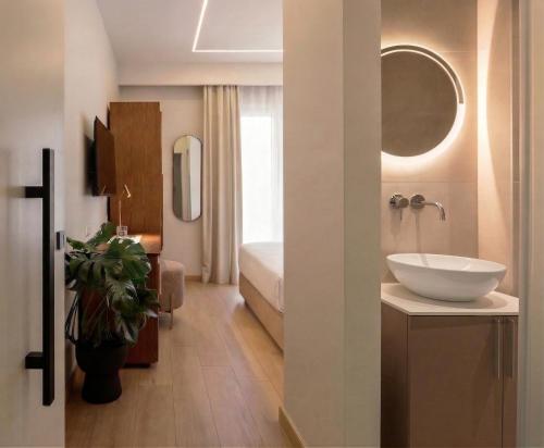 a bathroom with a sink and a bed in a room at Pillow by the Sea in Thessaloniki