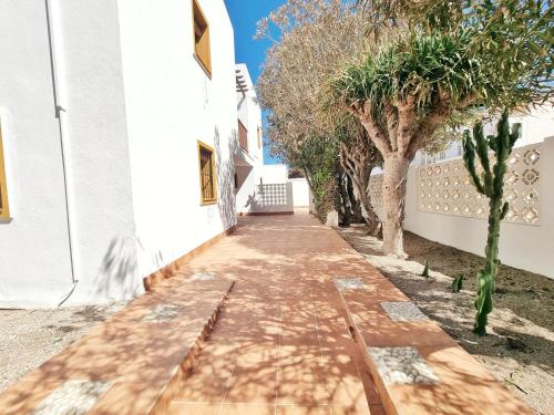 a walkway in front of a white building with trees at Casa REFUGIO DEL CABO, Cabo de Gata in El Cabo de Gata