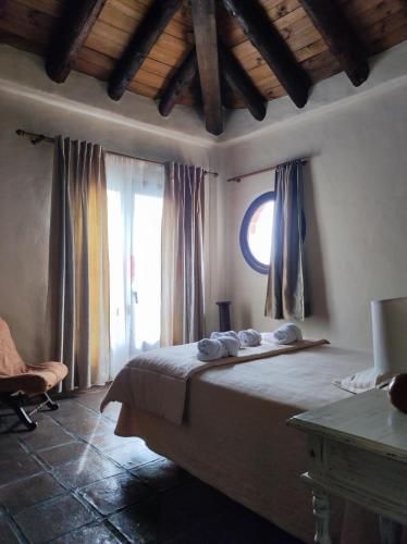 a bedroom with a large bed and a window at Hotel Rural Los Jarales in Istán
