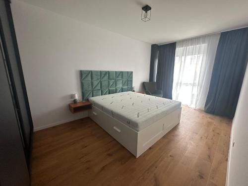 a bedroom with a white bed and a wooden floor at LaRa Apartament in Timişoara