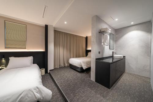 a hotel room with two beds and a sink at Nesto Hongdae in Seoul