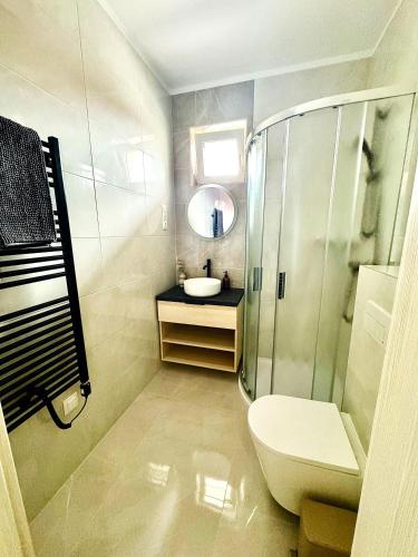 a bathroom with a toilet and a sink and a mirror at MEDA Apartman in Sárvár