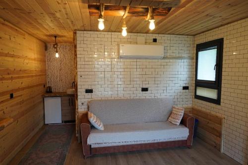 a couch in a room with a brick wall at Perla garden suit in Çamlıhemşin