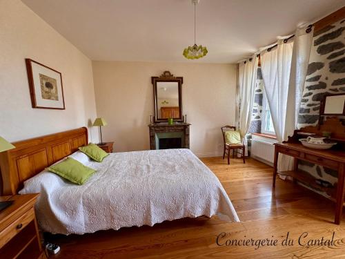 ein Schlafzimmer mit einem Bett, einem Tisch und einem Spiegel in der Unterkunft Celles - Demeure de la Tourille in Celles