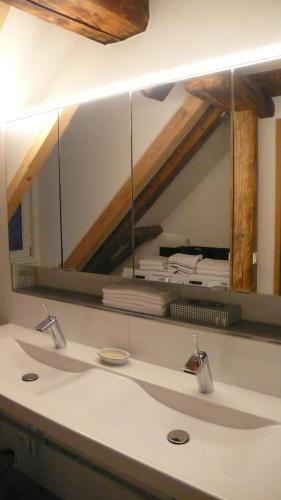 a bathroom sink with a large mirror above it at Design trifft Denkmal in Wangen im Allgäu