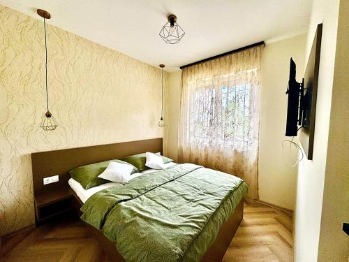 a bedroom with a bed and a window at MEDA Apartman in Sárvár