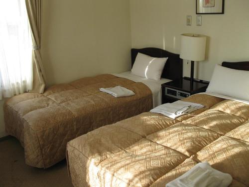 เตียงในห้องที่ Mito Riverside Hotel