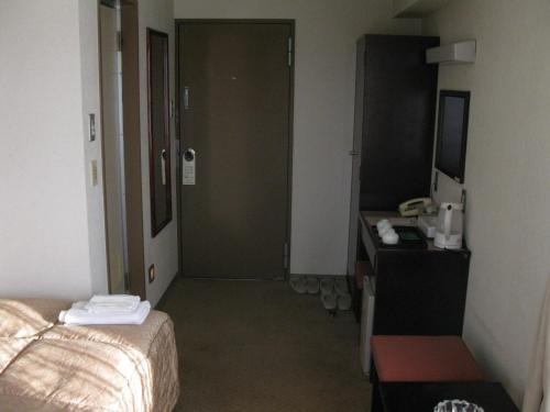 a hotel room with a bedroom with a bed and a desk at Mito Riverside Hotel in Mito