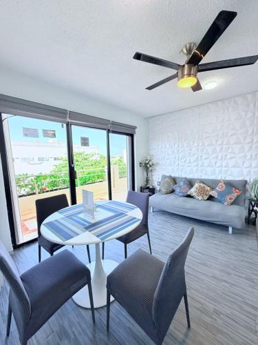 a living room with a ceiling fan and a table and chairs at MARLIN TURQUESA DEPARTAMENTOs FRENTE AL MAR in Cancún
