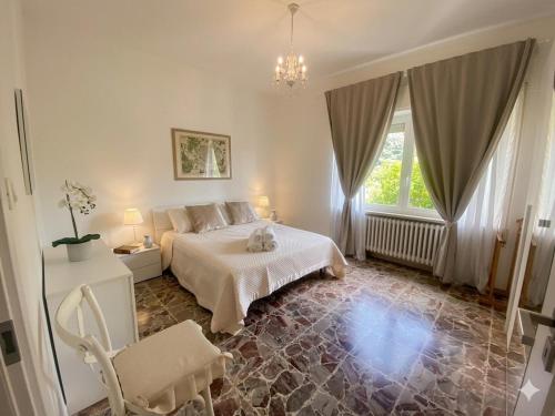 a bedroom with a bed and a chair in it at Casa Matilde e Aurora GIARDINO e POSTO AUTO in Sirolo