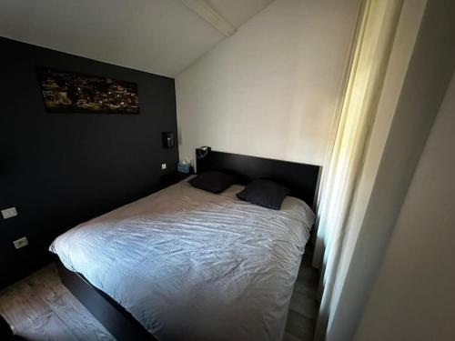 a bedroom with a bed in a black room at Charmant loft industriel de 40m2 in Aubignan