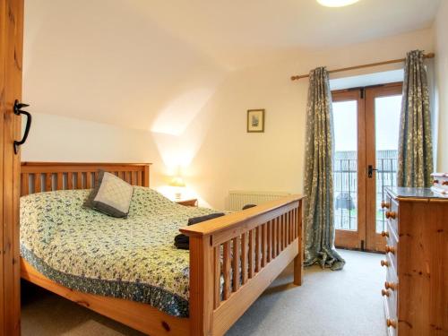a bedroom with a bed and a balcony at 3 Bed in Sherborne oc-folwr in Long Burton