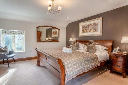 a bedroom with a bed and a chair and a mirror at 3 Bed in Crakehall oc-m30356 in Crakehall
