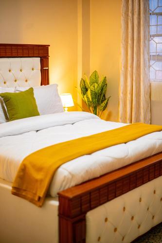 a bedroom with a bed with a yellow blanket on it at Chuma's home in Arusha