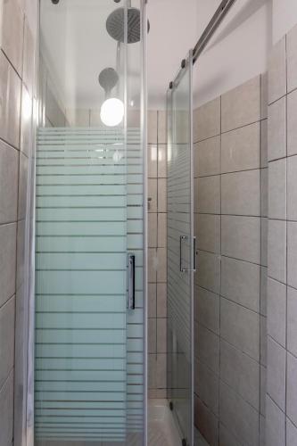 a bathroom with a shower with a glass door at Mia's Studio in Corfu