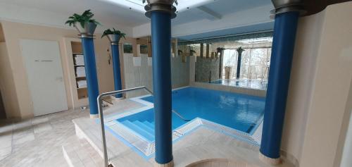 a large swimming pool with blue columns in a house at Flexibel Wohnen - BnoB in Füssen