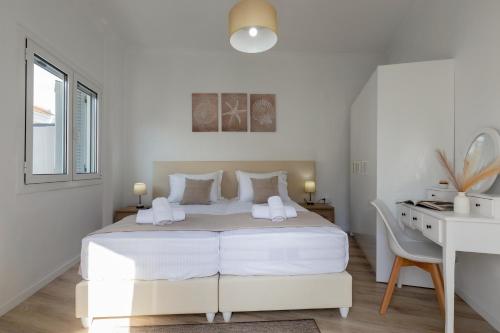 a white bedroom with a white bed and a desk at Mia's Studio in Corfu