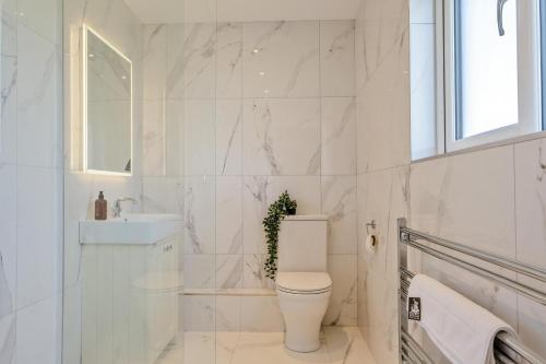 a white bathroom with a toilet and a sink at 3 Bed in Adgestone oc-a32613 in Brading