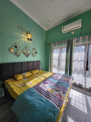 a bedroom with a bed in a room with green walls at Nature View Homestay in Dehradun
