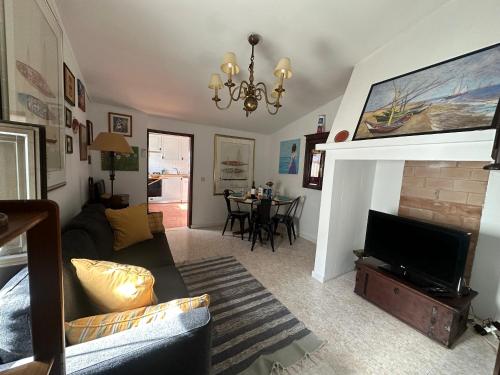 a living room with a couch and a television at Refúgio Alentejano in Estremoz