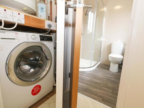 a washing machine in a bathroom with a toilet at Amber House in Dorchester