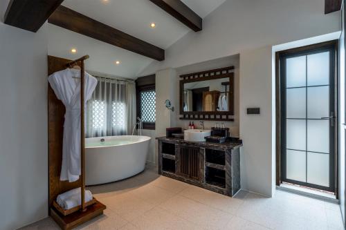 a bathroom with a bath tub and a sink at Maison lyly 300 Year Historical Cultural Courtyard and Ancient City View in Lijiang
