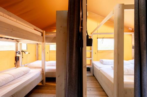 a room with three bunk beds in it at Glamping Saint Germain in Saint-Germain-du-Bel-Air