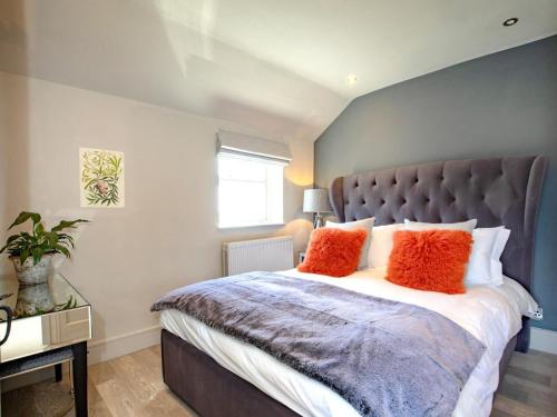 a bedroom with a large bed with orange pillows at 1 Bed in Richmond oc-82829 in Gilling