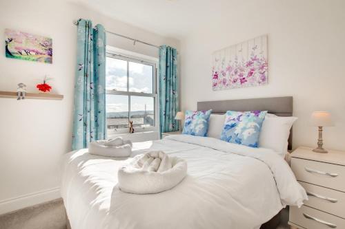 a bedroom with a large white bed with a window at 4 Bed in Leyburn oc-ds370 in Leyburn