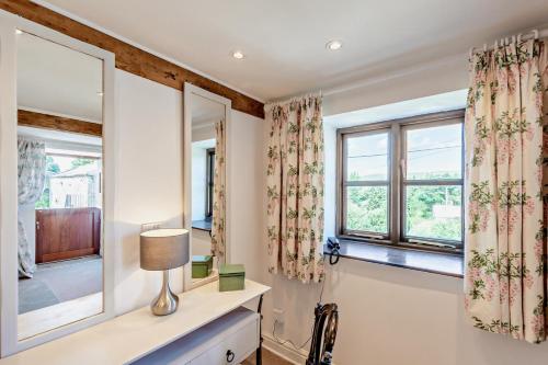 a room with two windows and a table with a lamp at 2 Bed in Askrigg oc-b27667 in Marsett