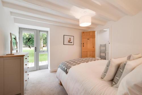 a white bedroom with a bed and a window at 4 Bed in Buxton oc-dcoldd in Hartington