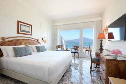 a hotel room with a bed and a desk and a window at Grand Hotel de la Ville in Sorrento