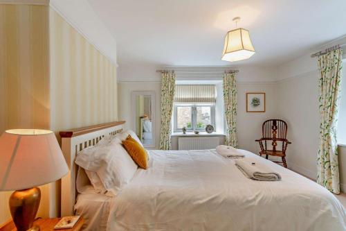 a bedroom with a white bed with a lamp and a chair at 3 Bed in Askrigg oc-h29661 in Askrigg
