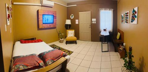 a bedroom with a bed and a chair in a room at City Garden 2 Apartment in Belize City