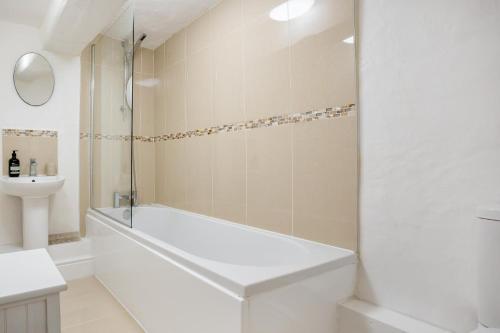 a white bathroom with a tub and a sink at 1 Bed in Askrigg oc-n28350 in Askrigg