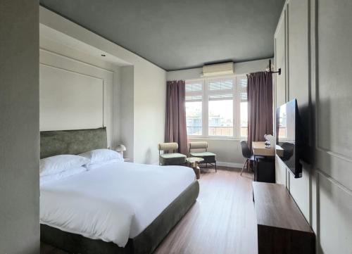 a hotel room with a bed and a desk and a television at Corso Italia Rooms in Milan