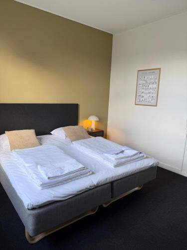 a bedroom with a bed with white sheets and pillows at Danhostel Tønder in Tønder