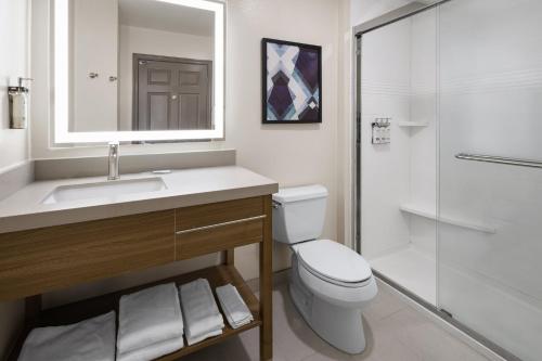 a bathroom with a toilet and a sink and a shower at Candlewood Williamsport by IHG in Williamsport