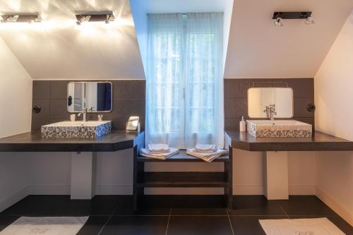 two sinks in a bathroom with two mirrors at le clos des belvals in Vertus