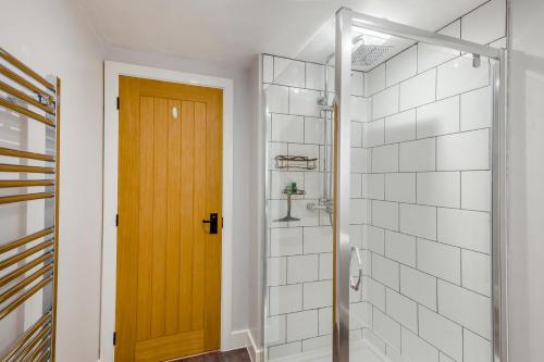 a bathroom with a shower and a wooden door at 1 Bed in Middleham oc-c30871 in Gammersgill